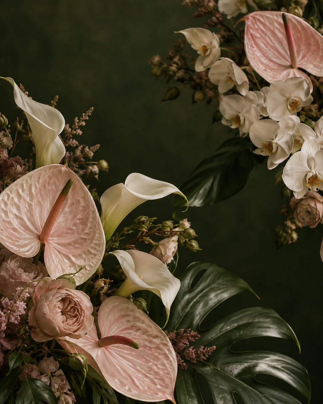 Sculptural blush anthuriums and ivory orchids against deep green